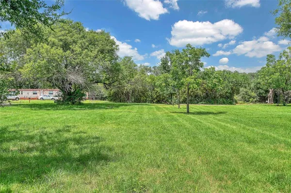 a view of a green field with wooden fence