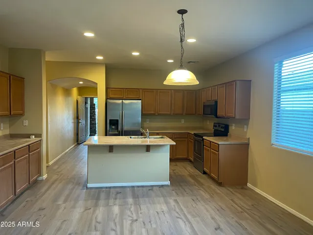 a kitchen with kitchen island a counter top space appliances and a window