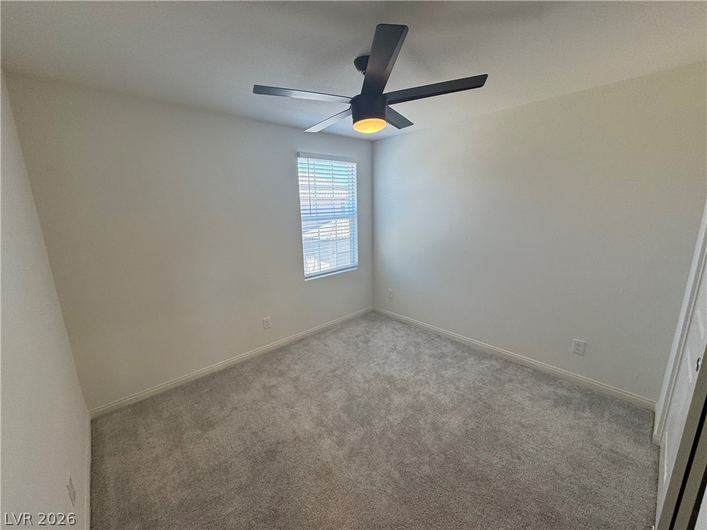 2821 Alcobaca Street Henderson, NV 89044 - Photo 13 of 24 A well-lit room awaits your personal touch, featuring soft carpeting and a modern ceiling fan.