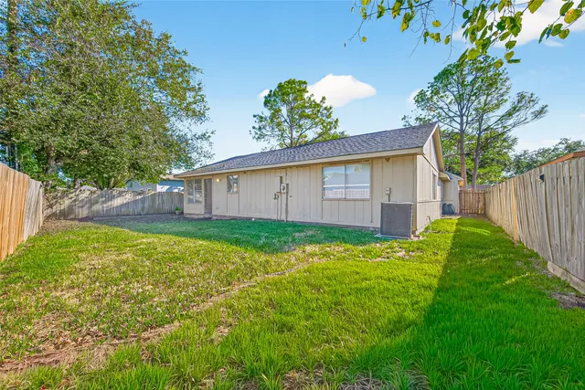 a view of a backyard with potted plants and large tree