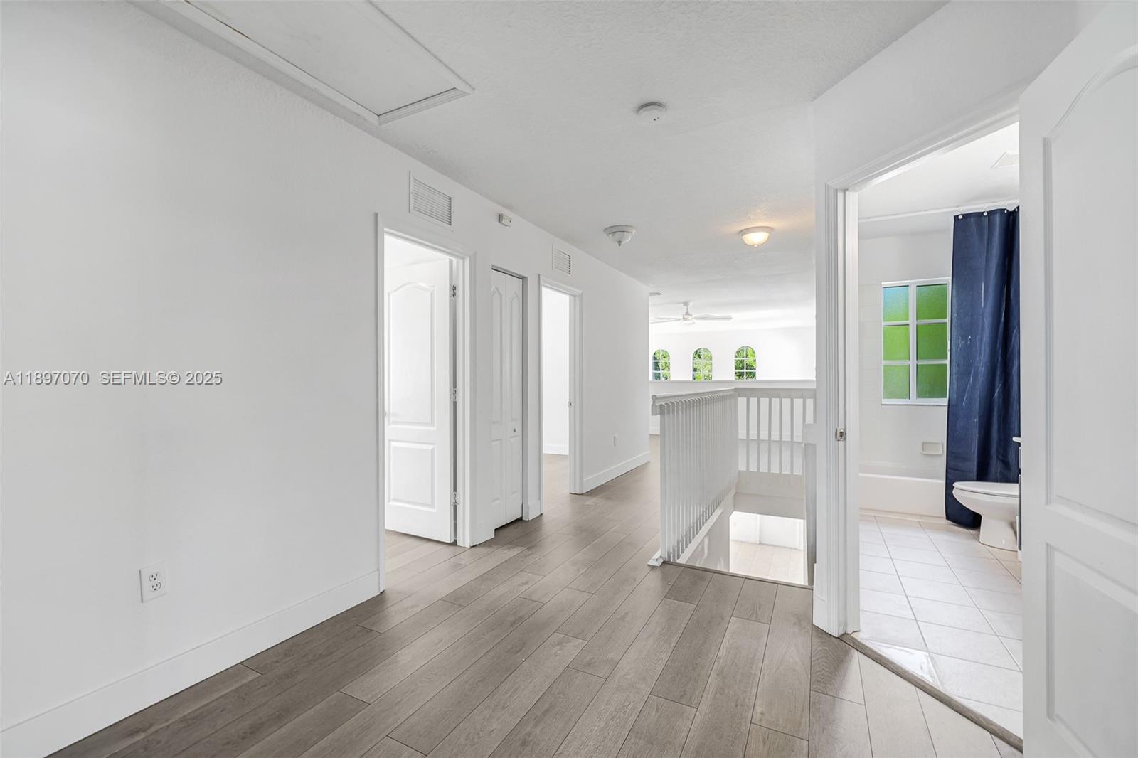 27381 Southwest 139th Place Homestead, FL 33032 - Photo 24 of 70 a view of a hallway with wooden floor and a bathroom