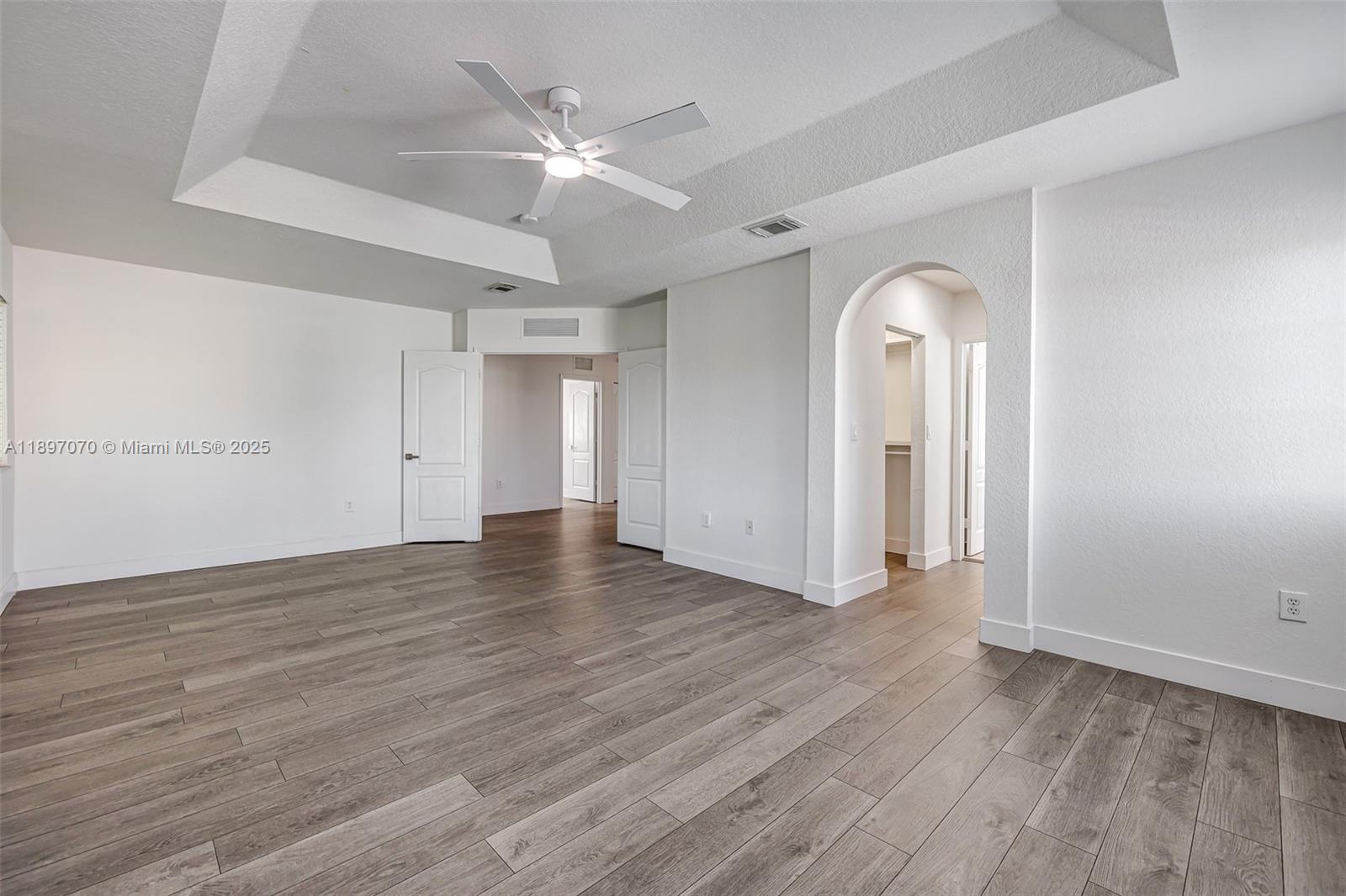27381 Southwest 139th Place Homestead, FL 33032 - Photo 29 of 70 an empty room with wooden floor and a ceiling fan