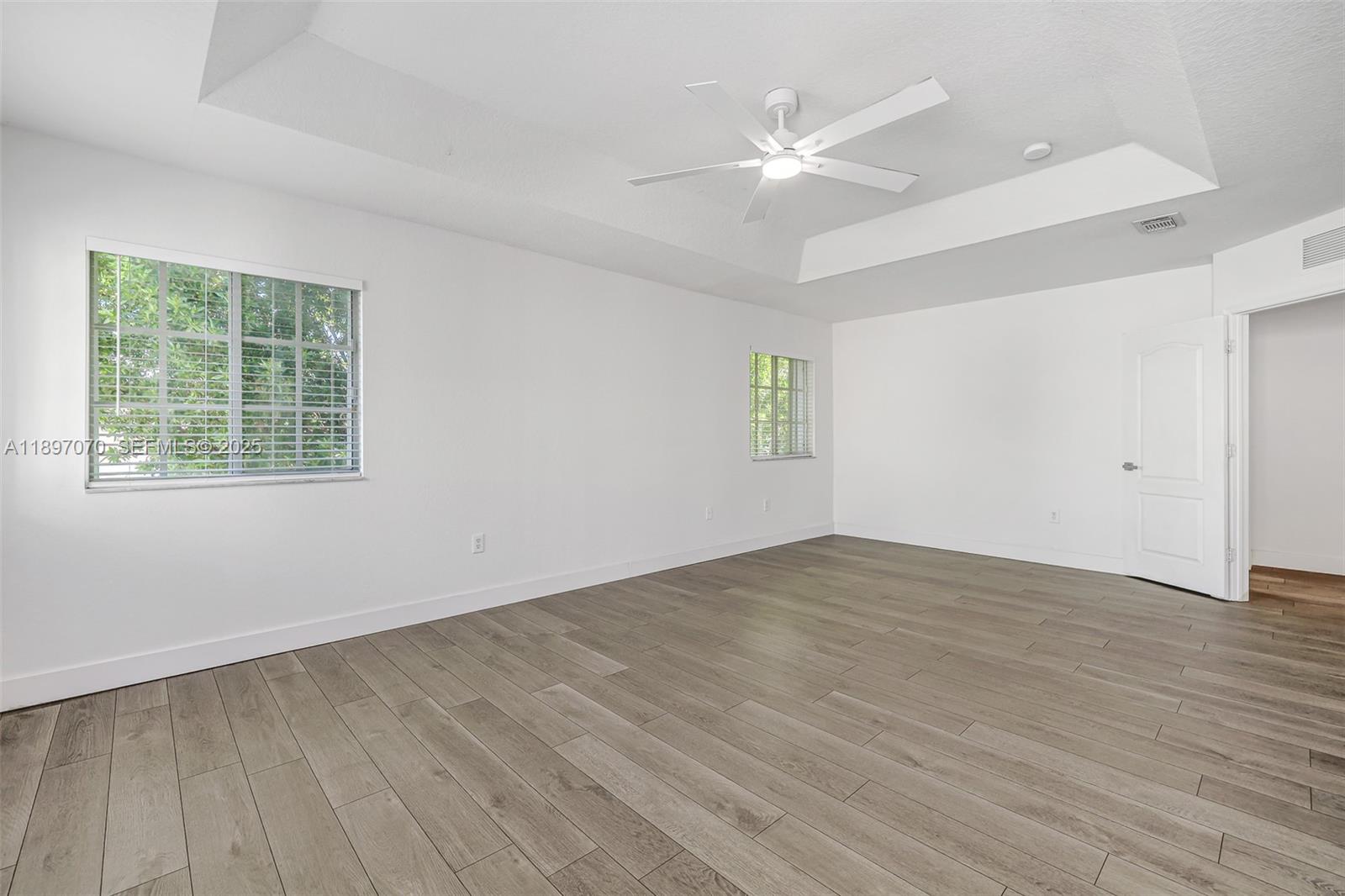 27381 Southwest 139th Place Homestead, FL 33032 - Photo 30 of 70 an empty room with wooden floor fan and windows