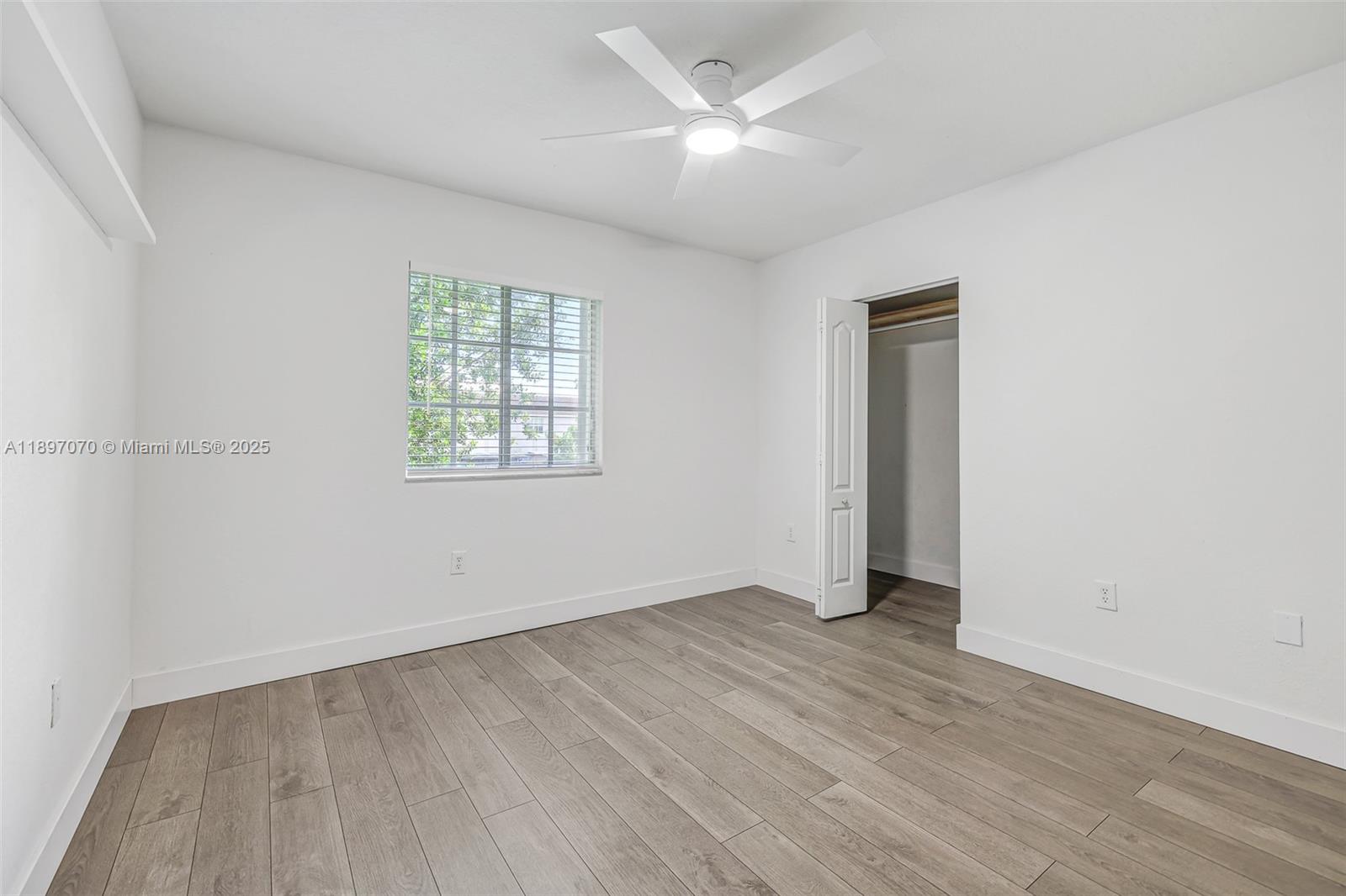 27381 Southwest 139th Place Homestead, FL 33032 - Photo 37 of 70 an empty room with wooden floor chandelier fan and windows