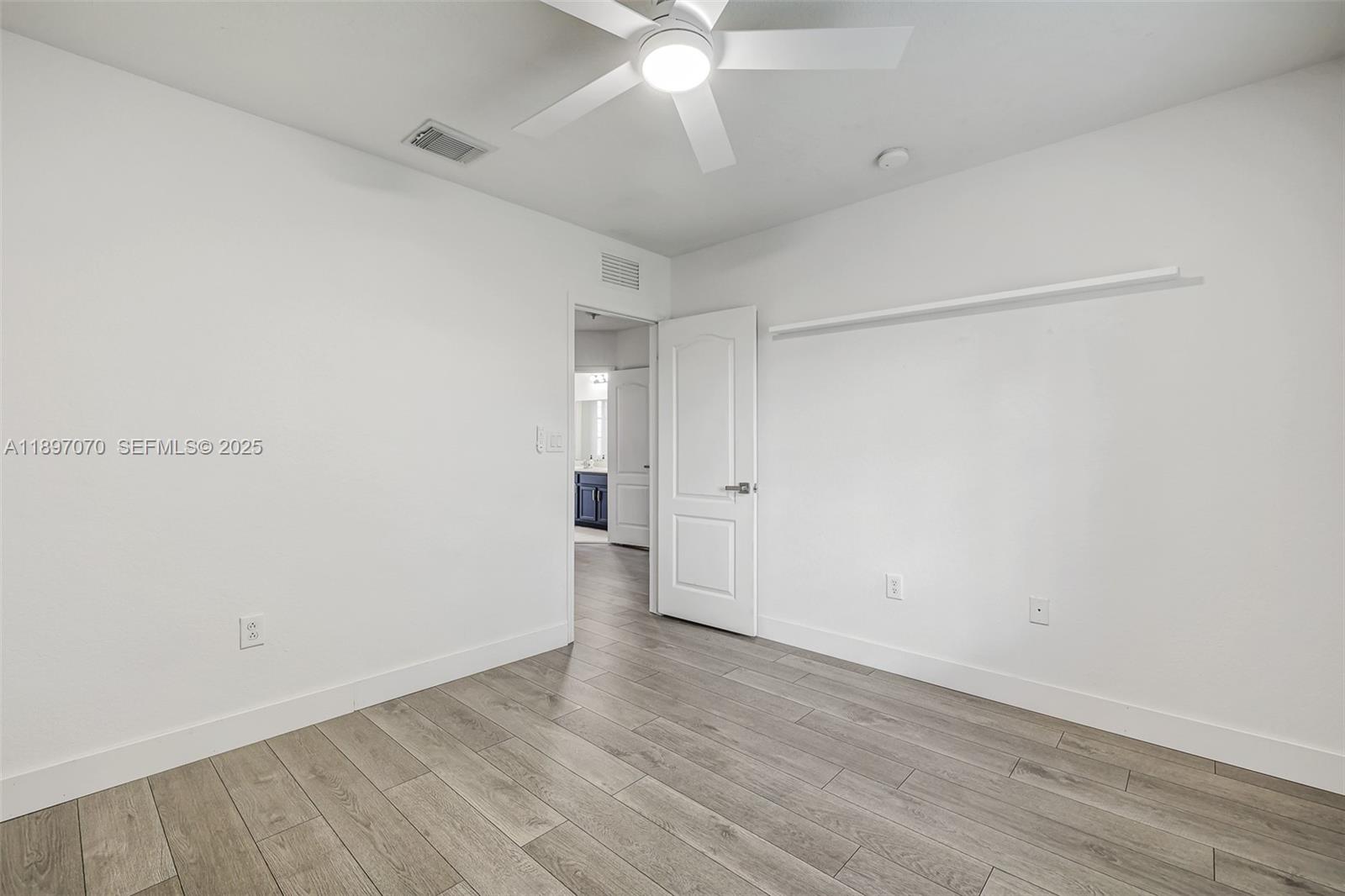 27381 Southwest 139th Place Homestead, FL 33032 - Photo 38 of 70 an empty room with wooden floor and fan