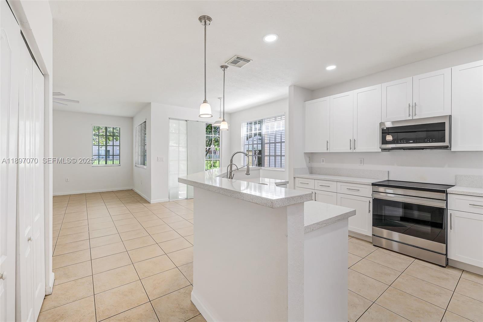 27381 Southwest 139th Place Homestead, FL 33032 - Photo 8 of 70 a kitchen with stainless steel appliances granite countertop a stove a sink and a refrigerator
