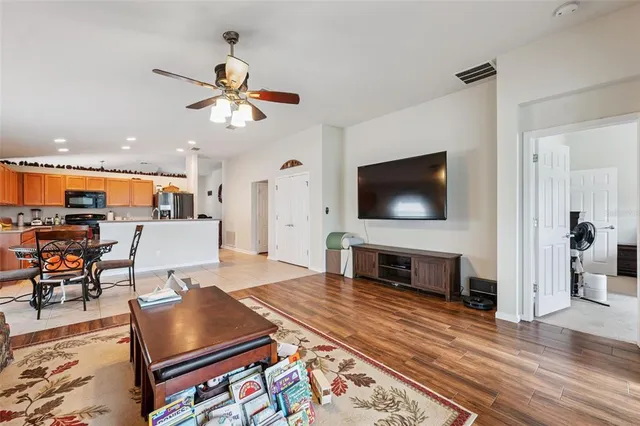 a living room with furniture a flat screen tv and kitchen view