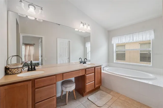 a bathroom with a sink mirror double vanity and bathtub