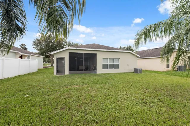 a view of a yard in front of a house with a large tree