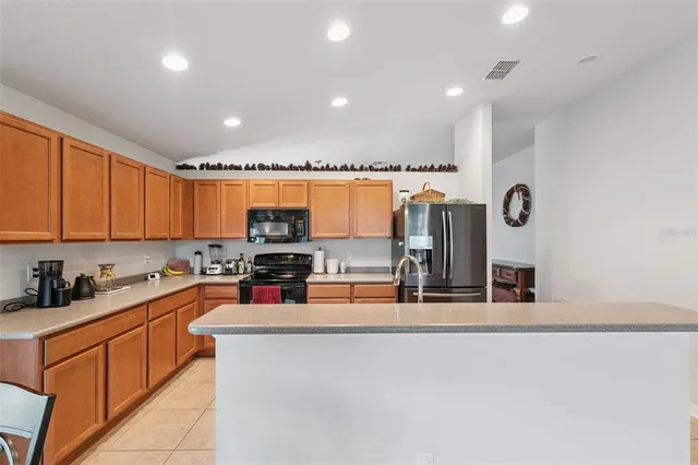 a kitchen with stainless steel appliances kitchen island granite countertop a sink and cabinets