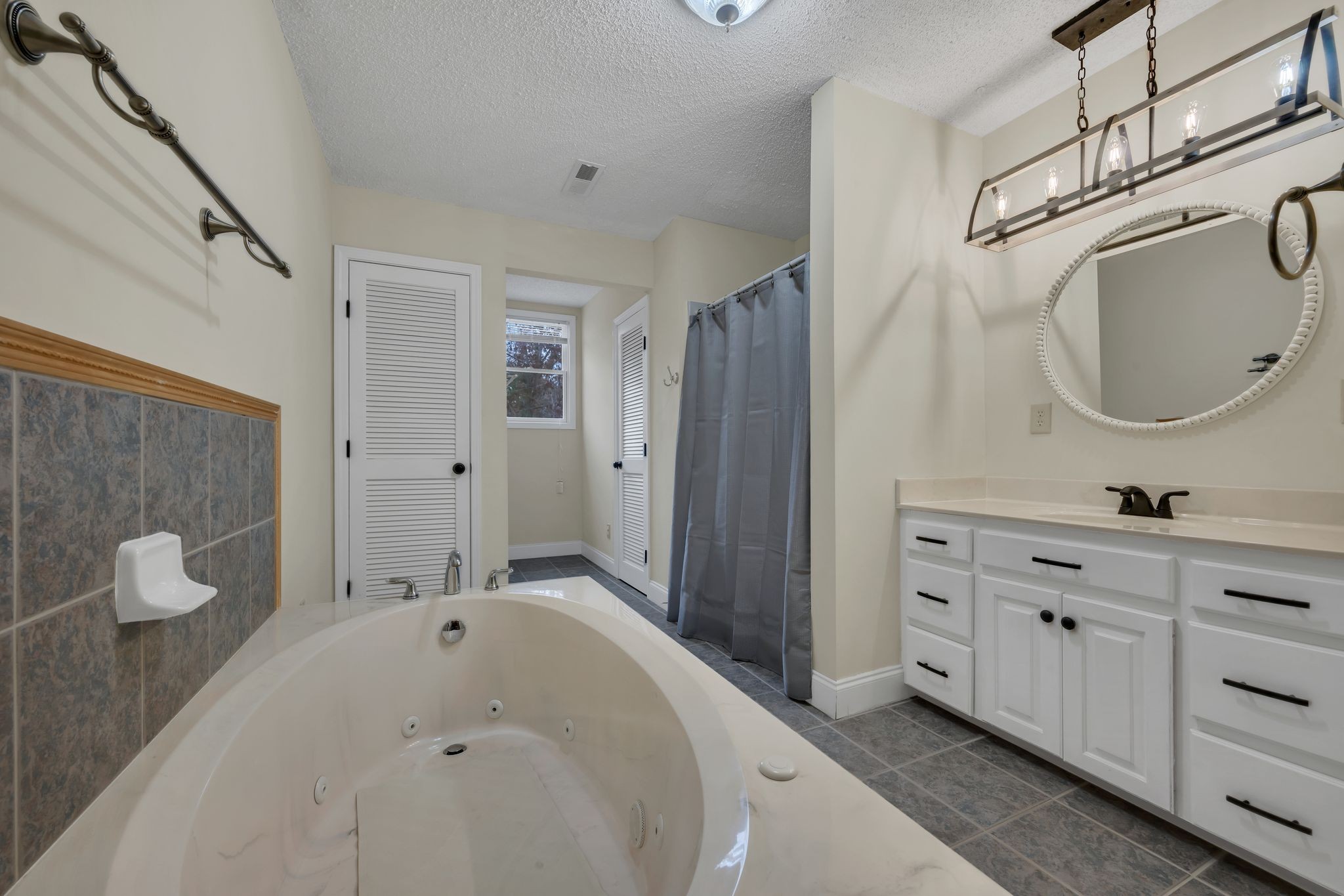 1265 Johnny Hall Road Burns, TN 37029 - Photo 46 of 89 This full bath boasts a large tub, walk-in shower, and unique, stylish light fixtures.