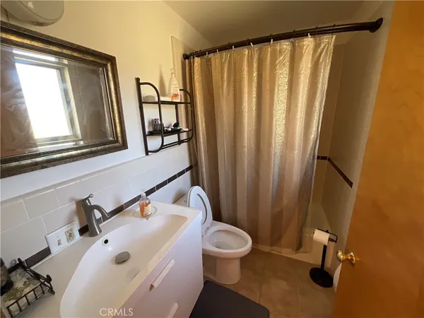 a bathroom with a sink and mirror with toilet