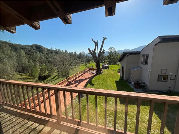 a view of a balcony with a floor to ceiling window and a tree