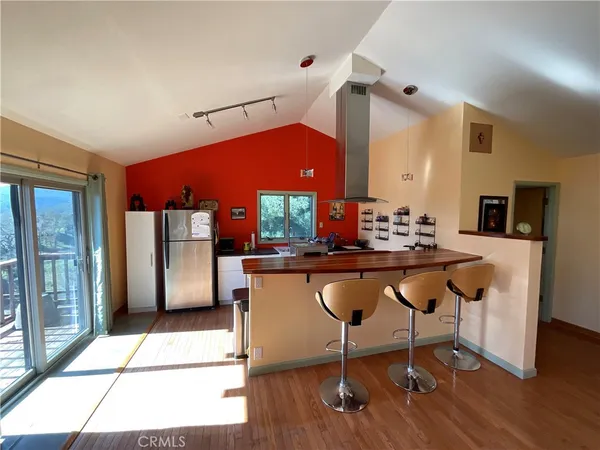 a living room with stainless steel appliances kitchen island granite countertop furniture a rug and a large window