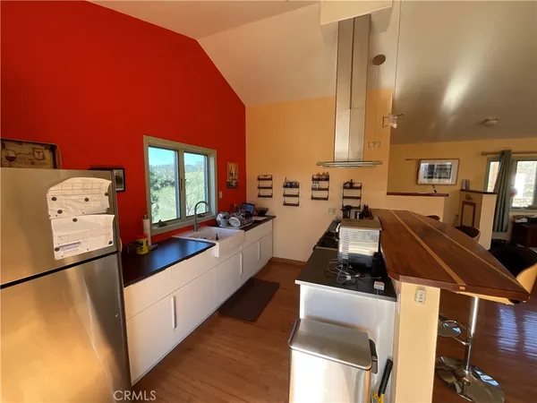 a large living room with stainless steel appliances kitchen island granite countertop furniture and a large window