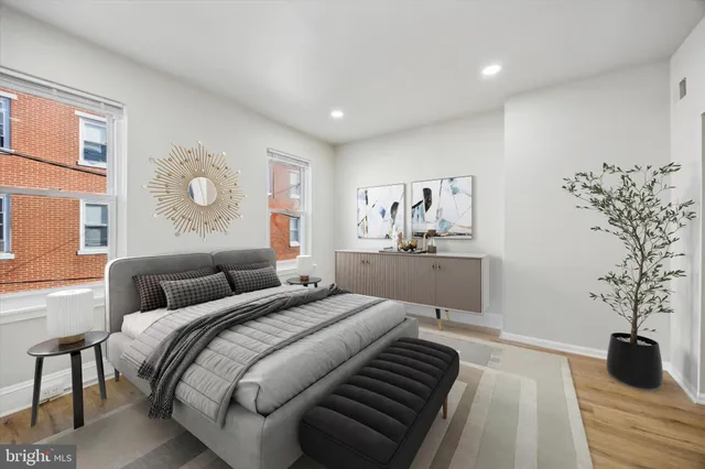 a bedroom with a large bed and a potted plant