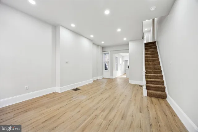 a view of hallway with stairs and wooden floor