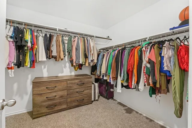 a view of walk in closet with clothes