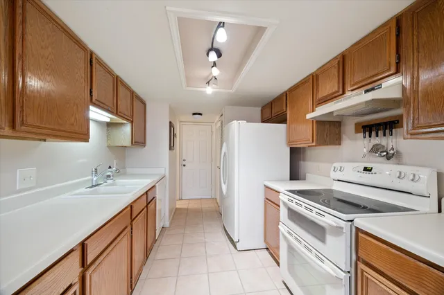 a kitchen with a sink a refrigerator and cabinets