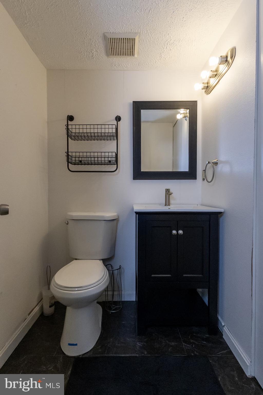511 Kosoak Road Baltimore, MD 21220 - Photo 42 of 63 a bathroom with a toilet a sink and mirror