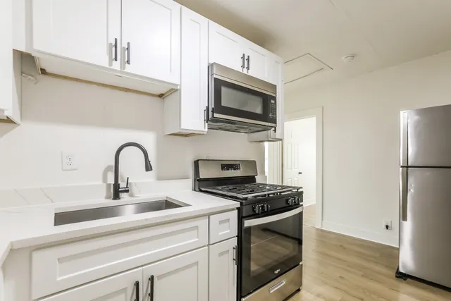 a kitchen with stainless steel appliances a stove microwave and a sink