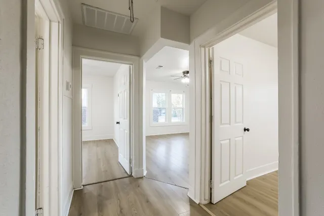 a view of a hallway with wooden floor