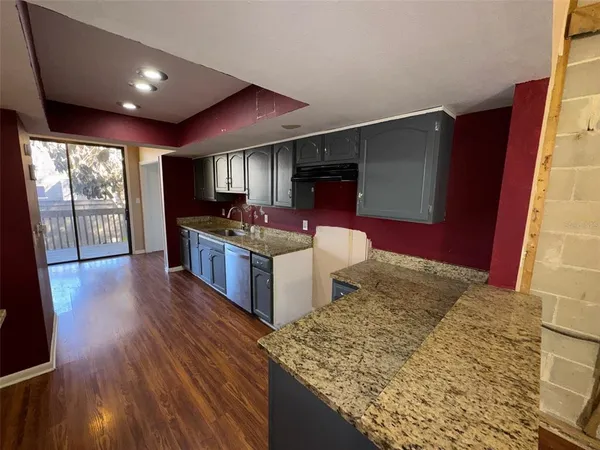 a kitchen with stainless steel appliances granite countertop a stove and a wooden floors
