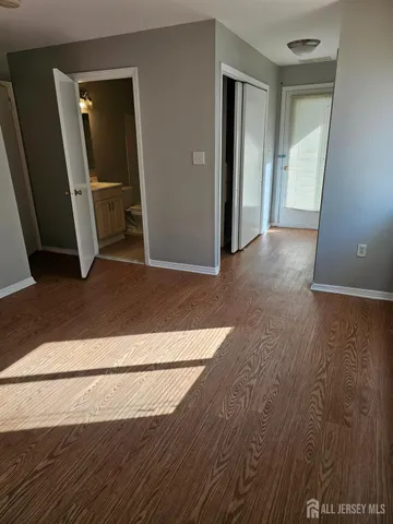 a view of a hallway with wooden floor and closet