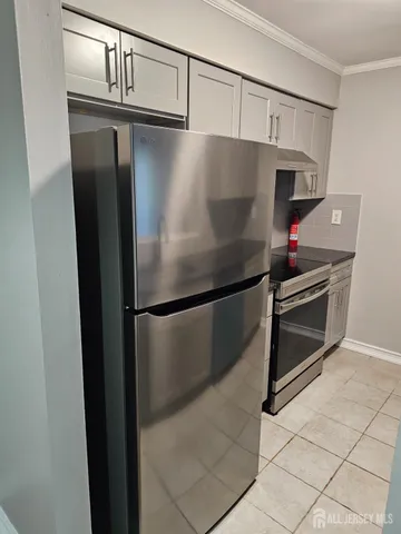 a metallic refrigerator freezer sitting in a kitchen