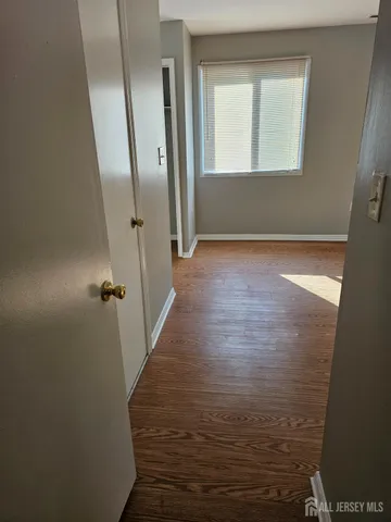 a view of a room with wooden floor and a window