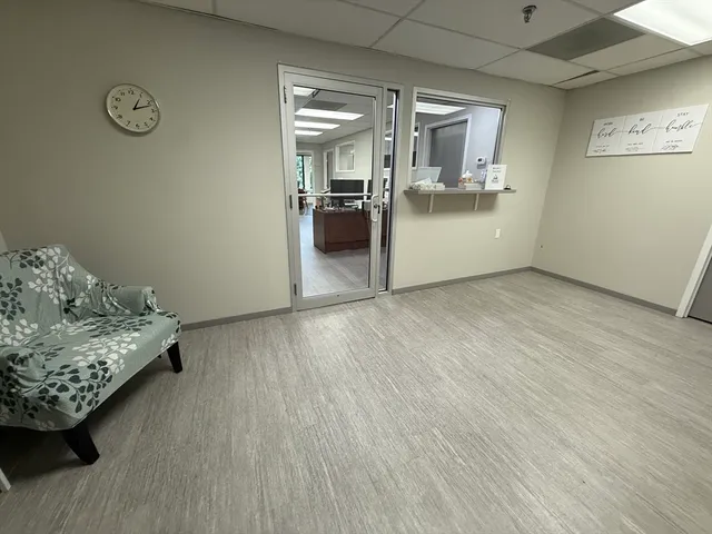 a view of a workspace with furniture and a window