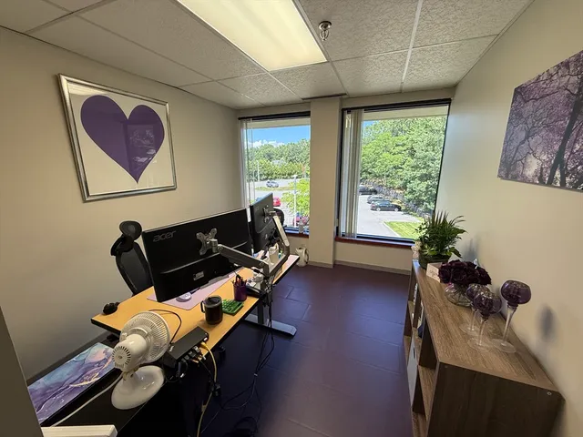 a view of a workspace with furniture and a window