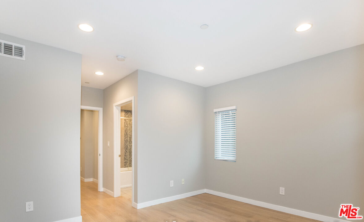 6546 La Mirada Avenue, Unit 6548 Los Angeles, CA 90038 - Photo 20 of 24 an empty room with wooden floor and windows