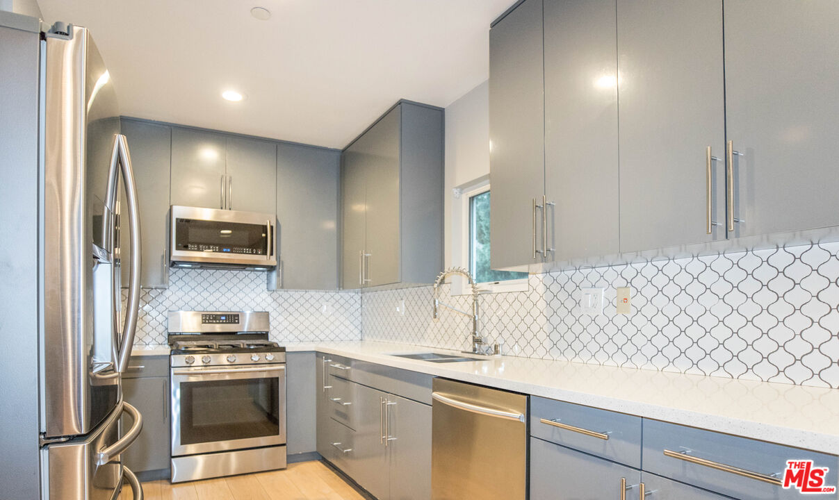 6546 La Mirada Avenue, Unit 6548 Los Angeles, CA 90038 - Photo 5 of 24 a kitchen with a sink and a stove top oven