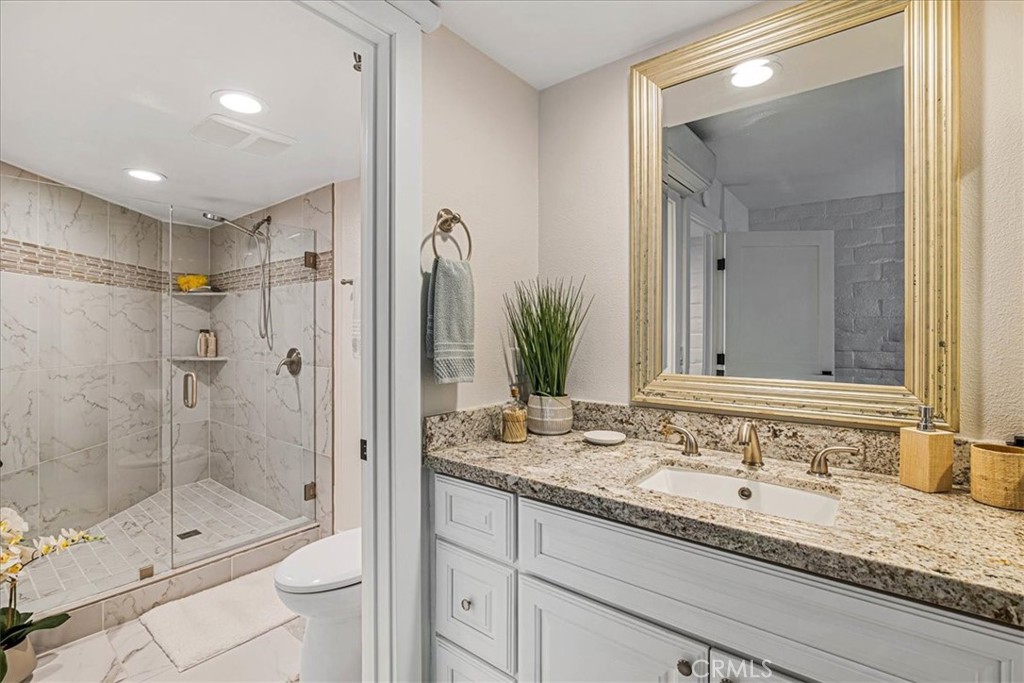 410 Corto Lane, Unit 9 San Clemente, CA 92672 - Photo 22 of 50 a bathroom with a granite countertop sink mirror and shower