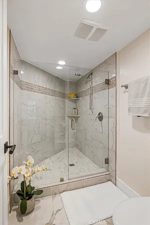a spacious bathroom with a glass shower door and a shower