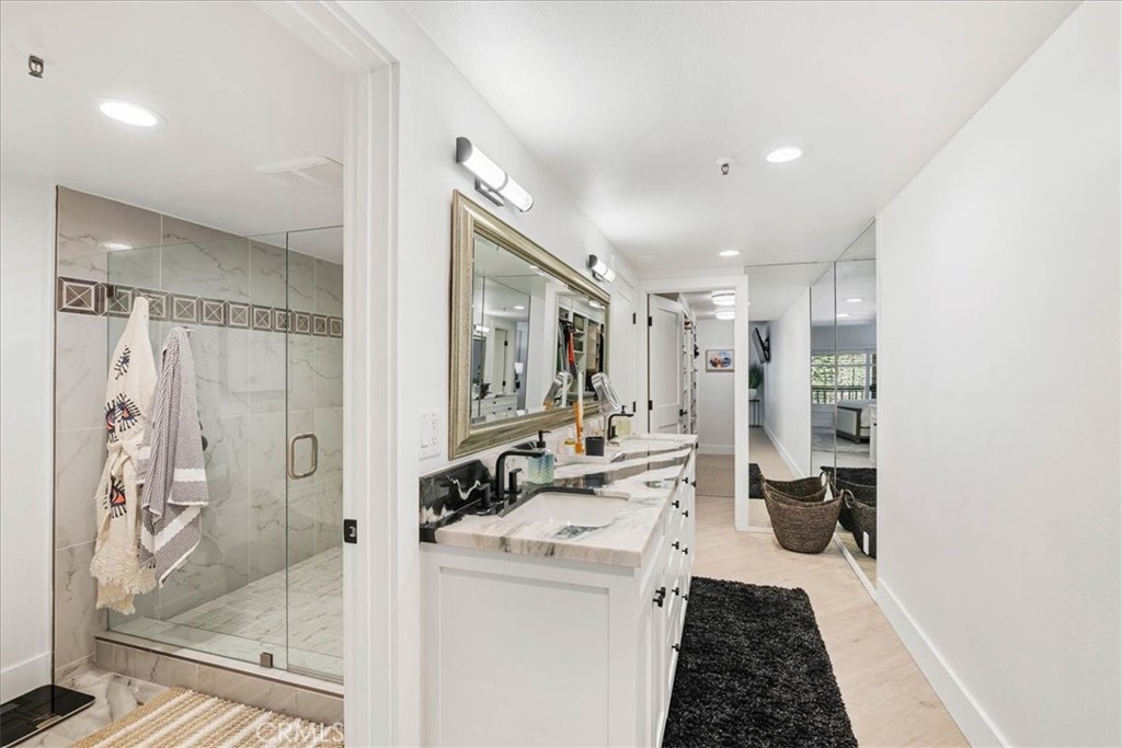 410 Corto Lane, Unit 9 San Clemente, CA 92672 - Photo 28 of 50 a bathroom with a double vanity sink a mirror and a shower