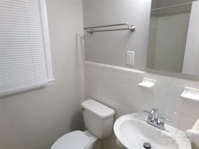 a bathroom with a sink mirror and toilet