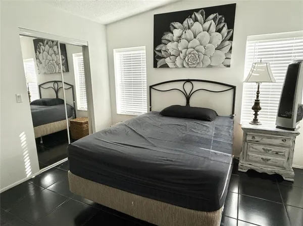 a bedroom with a bed and a painting on the wall