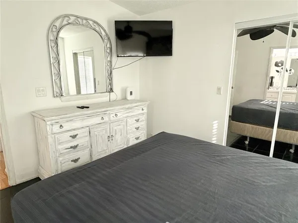 a spacious bedroom with a bed and a flat screen tv