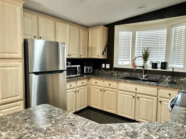a kitchen with stainless steel appliances granite countertop a refrigerator sink and cabinets