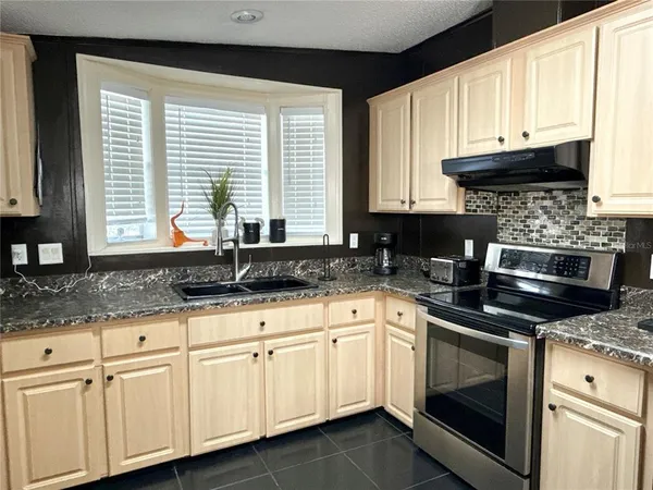 a kitchen with granite countertop white cabinets and a sink
