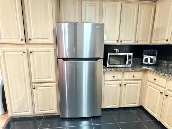 a white refrigerator freezer and a stove sitting inside of a kitchen