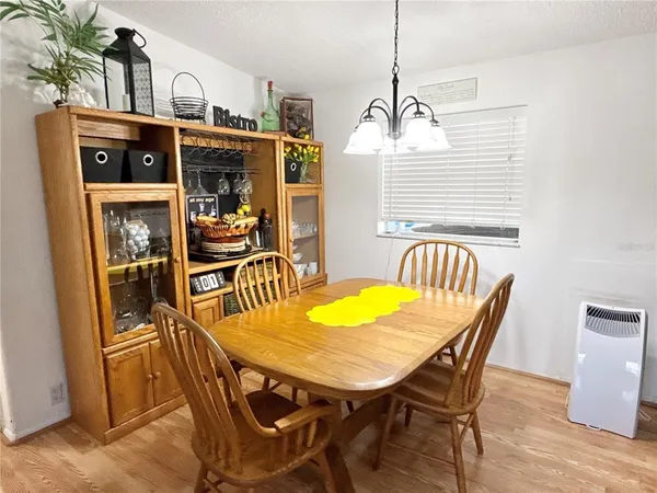 a view of a dining room and livingroom with furniture wooden floor and a chandelier