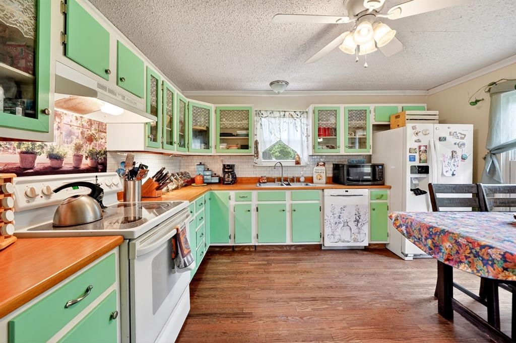 610 Crooked Creek Road Edgewood, TX 75117 - Photo 11 of 33 a kitchen that has a lot of cabinets a sink and a wooden floor in it