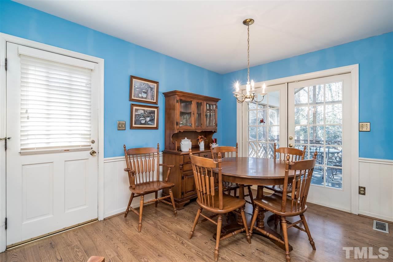 7301 Fiesta Way Raleigh, NC 27615 - Photo 13 of 25 a dining room with furniture a chandelier and wooden floor
