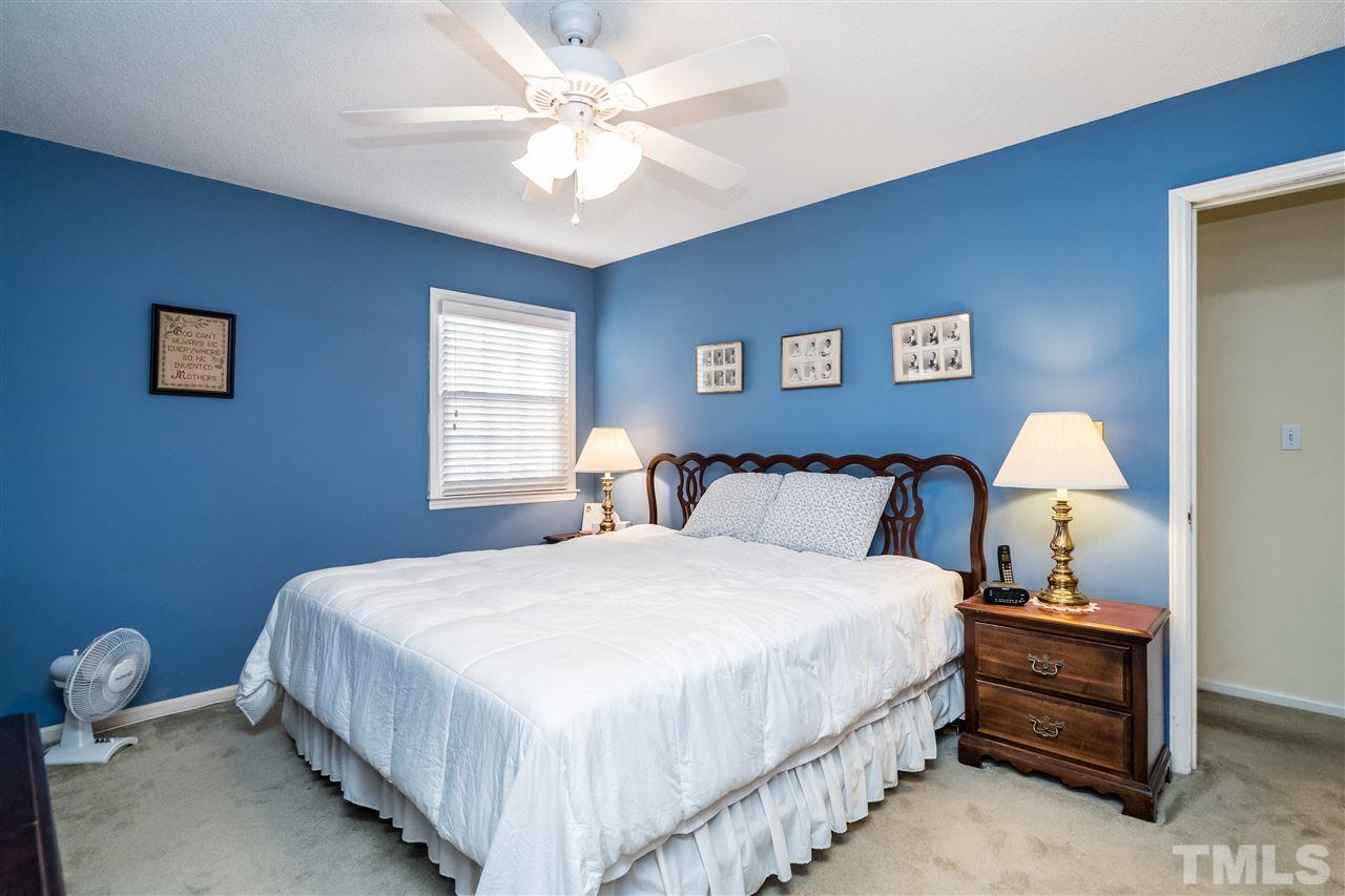 7301 Fiesta Way Raleigh, NC 27615 - Photo 15 of 25 a bedroom with a bed and a chandelier