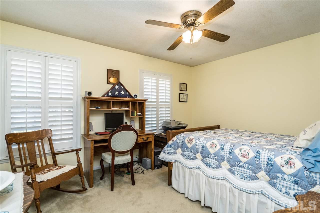 7301 Fiesta Way Raleigh, NC 27615 - Photo 18 of 25 a bedroom with a bed and a chandelier