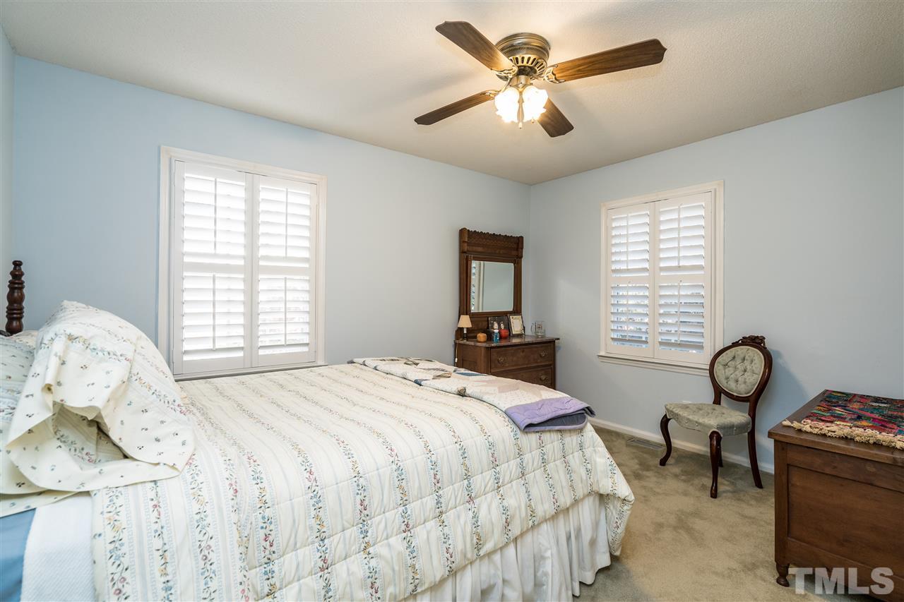 7301 Fiesta Way Raleigh, NC 27615 - Photo 19 of 25 a bedroom with a bed and a chandelier