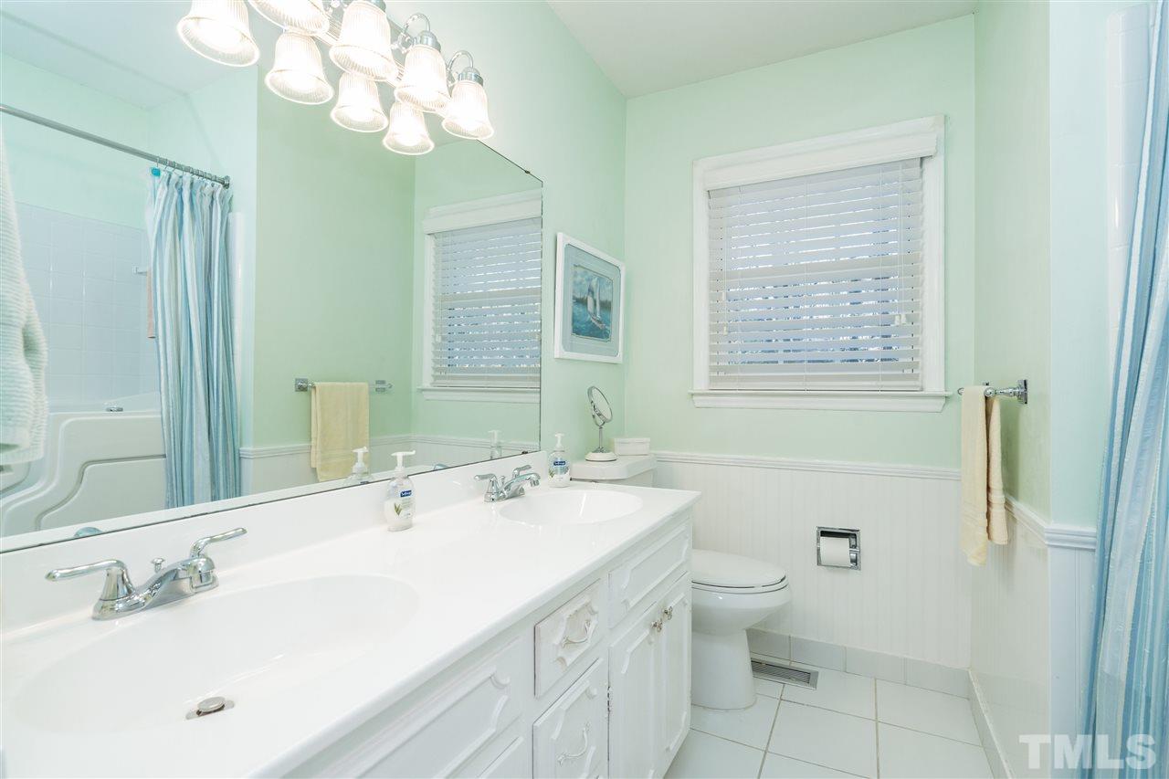 7301 Fiesta Way Raleigh, NC 27615 - Photo 20 of 25 a bathroom with a sink a toilet and a mirror